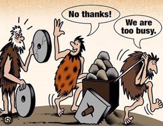 A cartoon shows cavemen pushing a cart with square wheels, struggling and sweating. One caveman offers them a round wheel as a solution, but they refuse, saying “No thanks!” and “We are too busy,” illustrating resistance to change and inefficiency despite an obvious improvement.