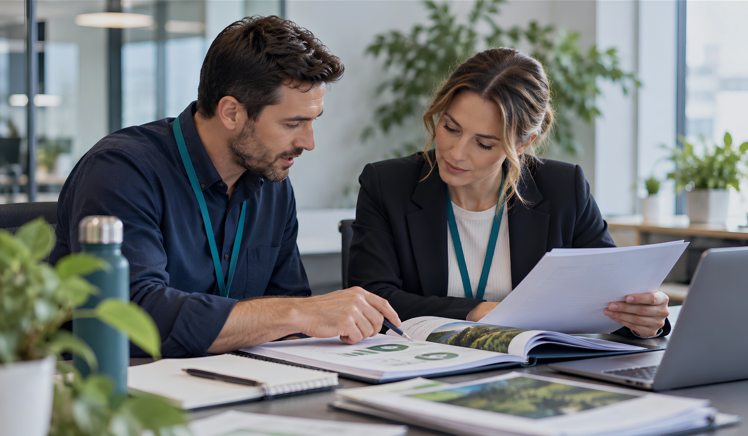 Two auditors review documents together during a management system audit.